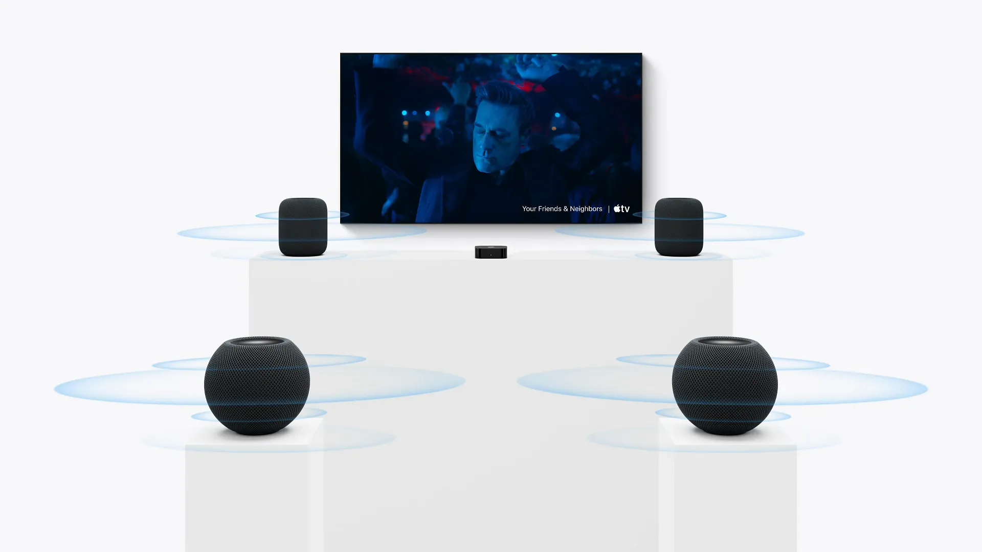 Television screen showing Godzilla above an Apple TV box and four HomePod speakers